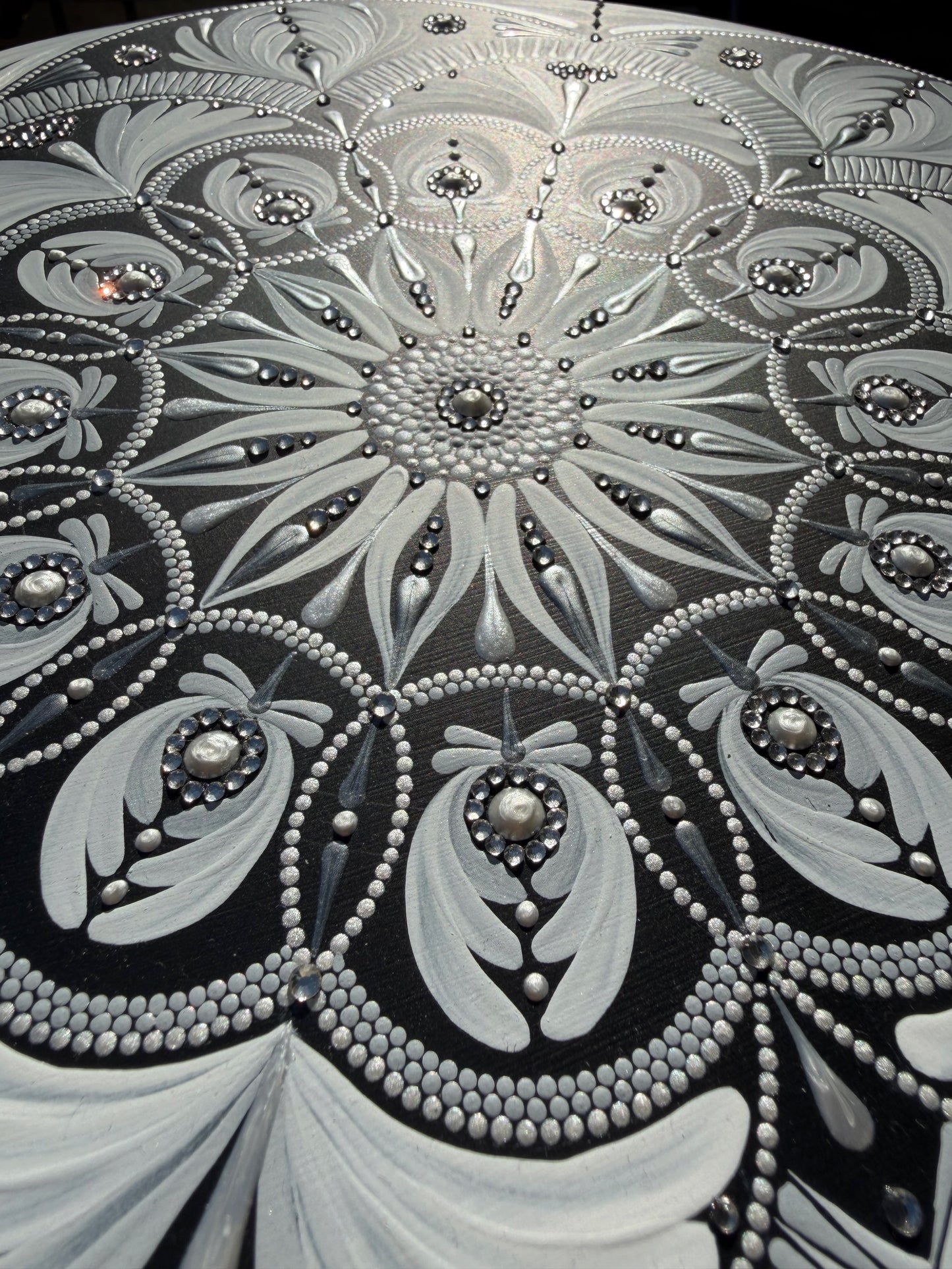 Close-up of a decorative mandala with intricate patterns and embellishments.
