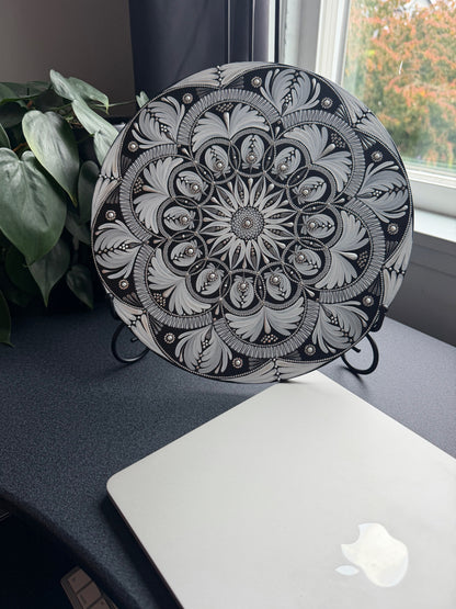 Decorative mandala with intricate black and white floral pattern on a white background